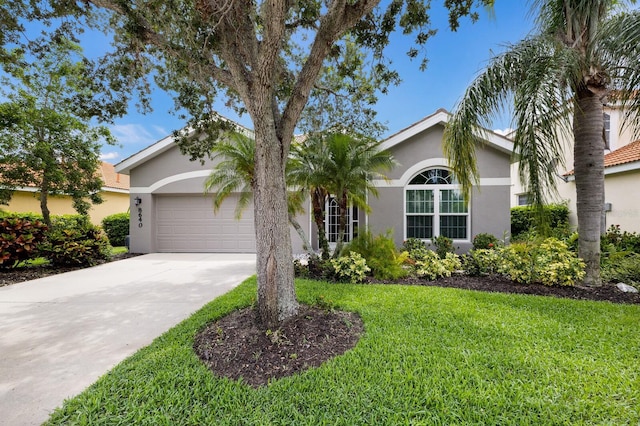 8640 Stone Harbour Loop, Bradenton, FL 34212 - view of front of house featuring stucco siding, an attached garage, and a front yard