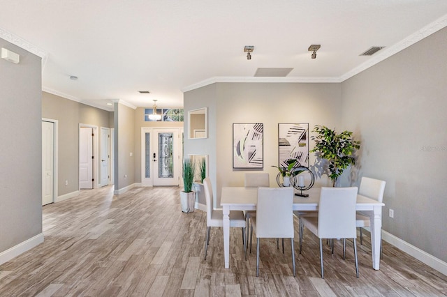 8640 Stone Harbour Loop, Bradenton, FL 34212 - dining space with baseboards, light wood finished floors, and ornamental molding