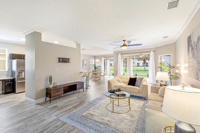 8640 Stone Harbour Loop, Bradenton, FL 34212 - living area with ornamental molding, a ceiling fan, light wood-type flooring, and baseboards