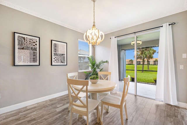 8640 Stone Harbour Loop, Bradenton, FL 34212 - dining area with a chandelier, healthy amount of natural light, light wood-style flooring, and ornamental molding