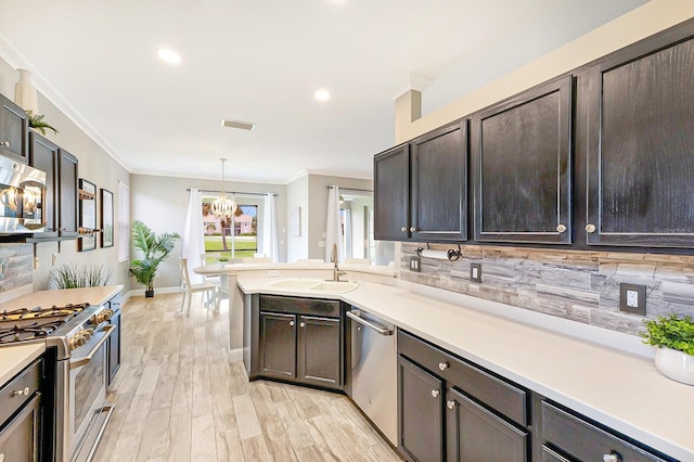 8640 Stone Harbour Loop, Bradenton, FL 34212 - kitchen featuring stainless steel appliances, ornamental molding, a sink, a chandelier, and decorative backsplash