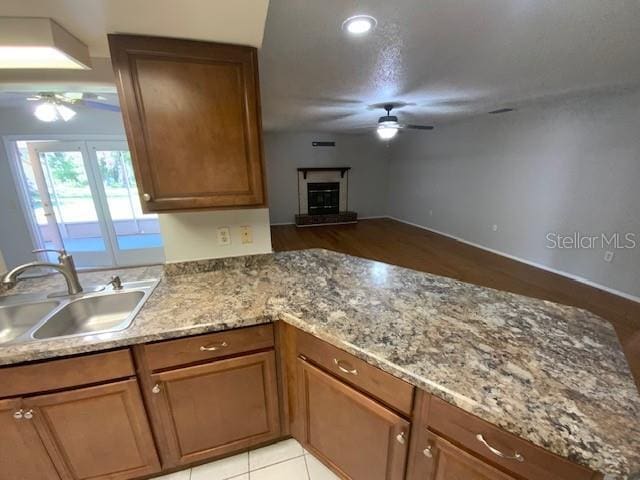 6923 13th Ave E, Bradenton, FL 34208 - kitchen with a ceiling fan, a sink, and brown cabinets