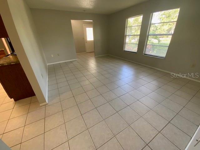 6923 13th Ave E, Bradenton, FL 34208 - spare room featuring light tile patterned floors and baseboards