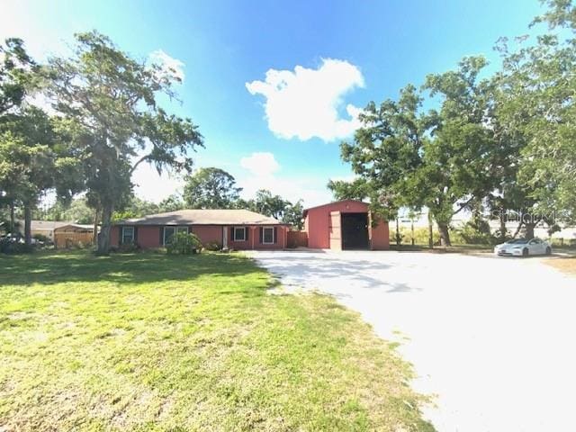 6923 13th Ave E, Bradenton, FL 34208 - view of front facade with a front yard, driveway, an outbuilding, and a garage