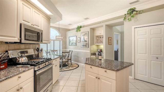 4612 4th Ave E, Bradenton, FL 34208 - kitchen with stainless steel appliances, crown molding, light tile patterned floors, dark stone countertops, and baseboards