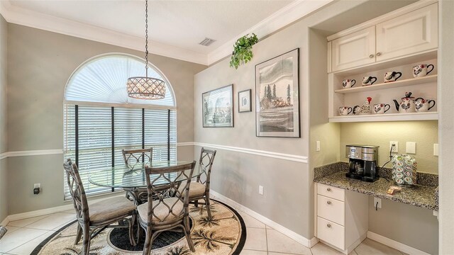 4612 4th Ave E, Bradenton, FL 34208 - dining room featuring healthy amount of natural light, light tile patterned flooring, crown molding, and baseboards