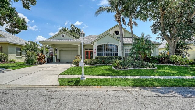 4612 4th Ave E, Bradenton, FL 34208 - view of front of property with a garage, stucco siding, driveway, a front lawn, and french doors