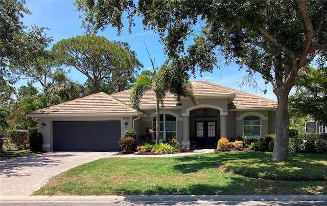 2149 Muskogee Trl, Nokomis, FL 34275 - view of front of house with french doors, a front lawn, a garage, stucco siding, and driveway