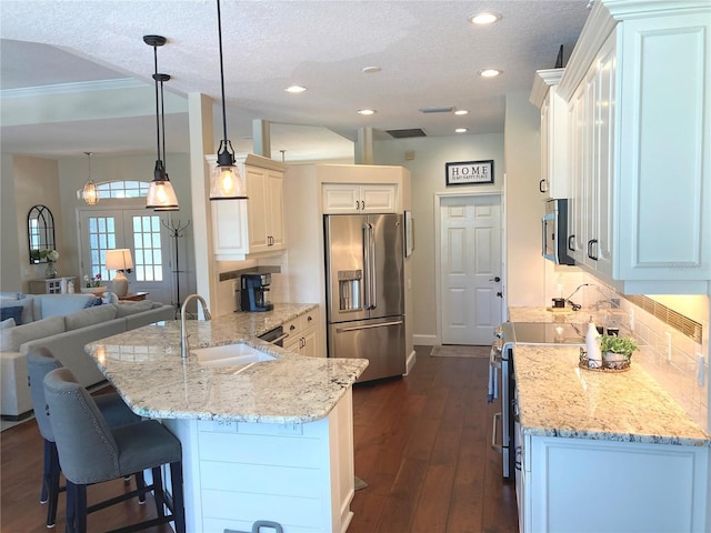 2149 Muskogee Trl, Nokomis, FL 34275 - kitchen featuring appliances with stainless steel finishes, a sink, a peninsula, light stone countertops, and a textured ceiling