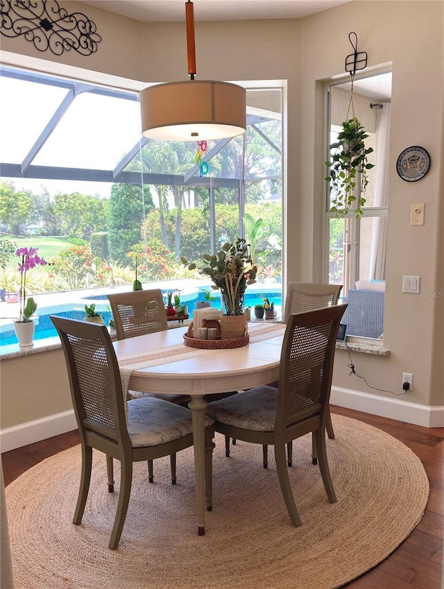 2149 Muskogee Trl, Nokomis, FL 34275 - dining room with a sunroom, baseboards, and wood finished floors