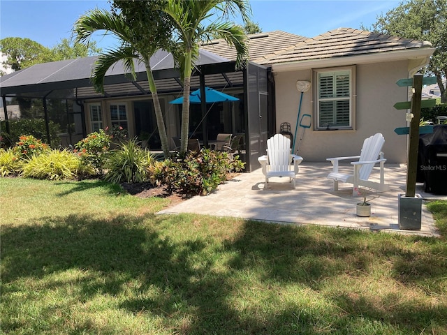 2149 Muskogee Trl, Nokomis, FL 34275 - back of property featuring stucco siding, a yard, a patio, glass enclosure, and a tile roof