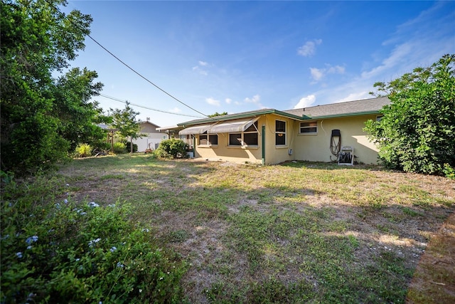 3468 Roslyn Rd, Venice, FL 34293 - back of property with stucco siding and a lawn