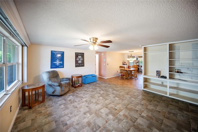 3468 Roslyn Rd, Venice, FL 34293 - living area with baseboards, a textured ceiling, a ceiling fan, and a chandelier