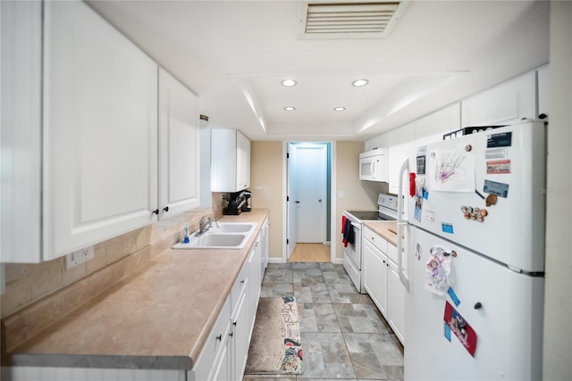3468 Roslyn Rd, Venice, FL 34293 - kitchen featuring white appliances, a sink, a tray ceiling, recessed lighting, and white cabinetry