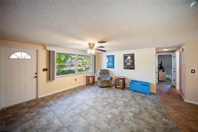 3468 Roslyn Rd, Venice, FL 34293 - entryway featuring a textured ceiling, ceiling fan, baseboards, and stone finish flooring