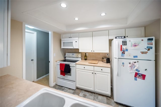 3468 Roslyn Rd, Venice, FL 34293 - kitchen with white appliances, a tray ceiling, white cabinets, and recessed lighting