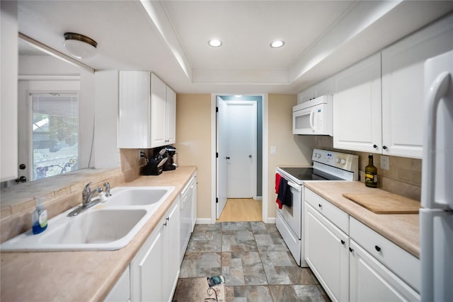3468 Roslyn Rd, Venice, FL 34293 - kitchen featuring white appliances, a sink, baseboards, tasteful backsplash, and white cabinetry