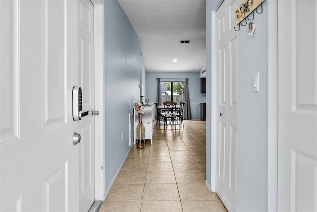 4076 Vana Dr, Sarasota, FL 34241 - hall featuring light tile patterned floors, a textured ceiling, and baseboards