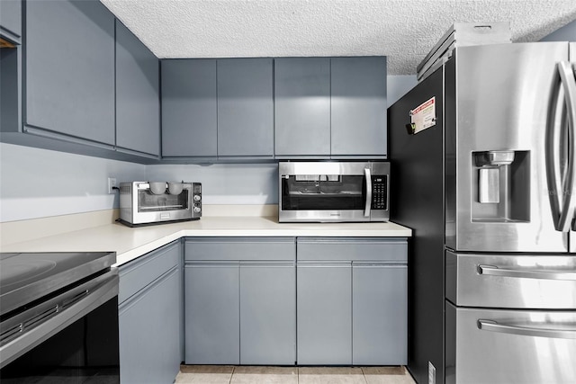 4076 Vana Dr, Sarasota, FL 34241 - kitchen with appliances with stainless steel finishes, a textured ceiling, gray cabinets, and light countertops