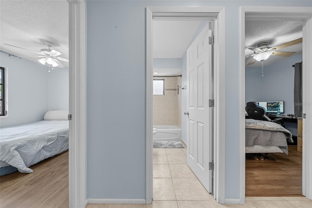 4076 Vana Dr, Sarasota, FL 34241 - bedroom with a textured ceiling, light tile patterned flooring, multiple windows, a ceiling fan, and ensuite bathroom
