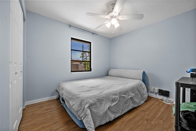 4076 Vana Dr, Sarasota, FL 34241 - bedroom with wood finished floors, baseboards, a textured ceiling, a ceiling fan, and a closet