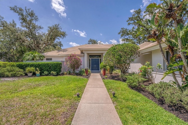 2914 Dick Wilson Dr, Sarasota, FL 34240 - view of front of home with stucco siding, a front yard, and a tile roof