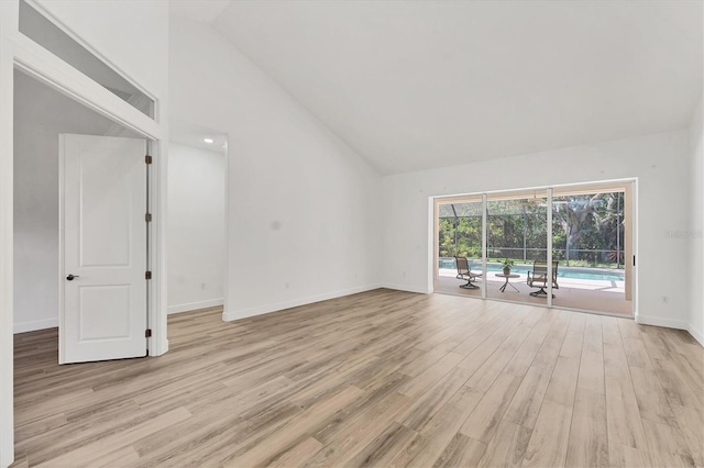 2914 Dick Wilson Dr, Sarasota, FL 34240 - empty room featuring light wood finished floors, high vaulted ceiling, and baseboards