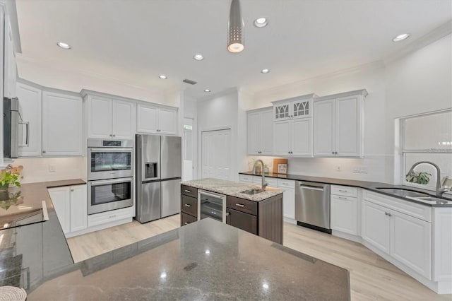 2914 Dick Wilson Dr, Sarasota, FL 34240 - kitchen with appliances with stainless steel finishes, a sink, crown molding, wine cooler, and decorative backsplash