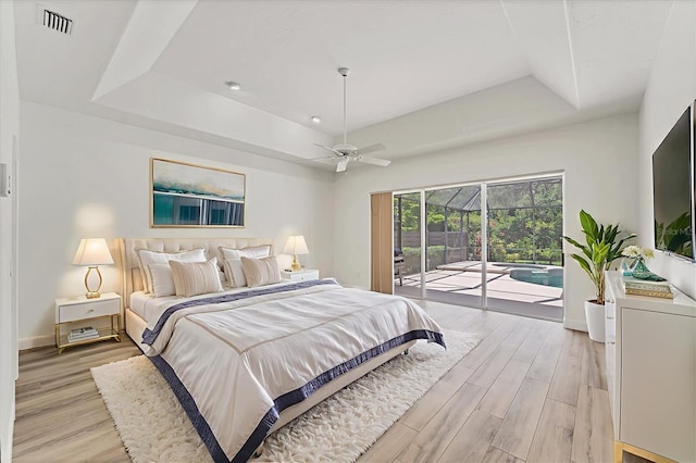2914 Dick Wilson Dr, Sarasota, FL 34240 - bedroom featuring a tray ceiling, access to exterior, and light wood-style floors