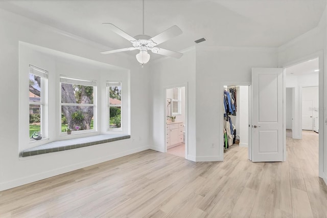 2914 Dick Wilson Dr, Sarasota, FL 34240 - unfurnished bedroom with a walk in closet, crown molding, light wood-style floors, a closet, and ensuite bath