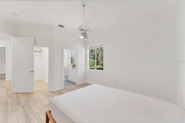 2914 Dick Wilson Dr, Sarasota, FL 34240 - bedroom featuring a spacious closet, light wood-style flooring, baseboards, ceiling fan, and a closet