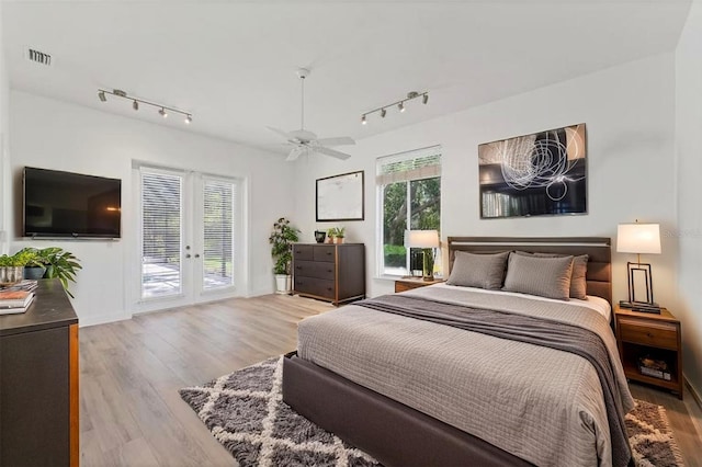 2914 Dick Wilson Dr, Sarasota, FL 34240 - bedroom featuring rail lighting, access to outside, wood finished floors, and ceiling fan