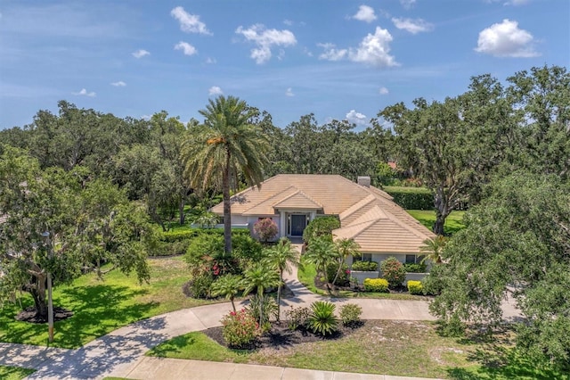 2914 Dick Wilson Dr, Sarasota, FL 34240 - view of front of property featuring a tiled roof, a front yard, and curved driveway