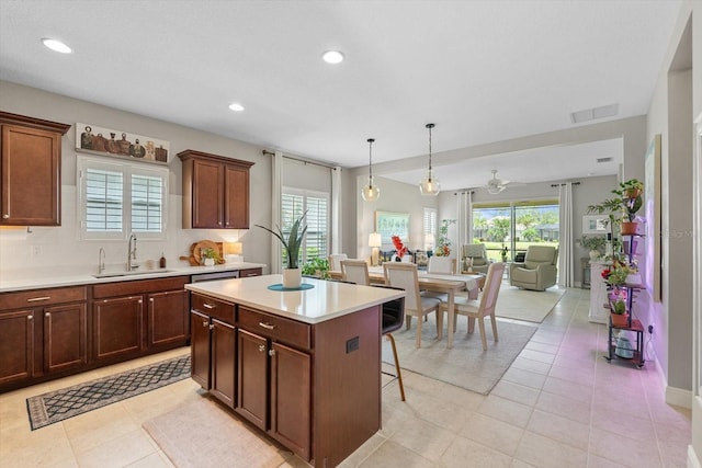 12327 Halfmoon Lake Ter, Bradenton, FL 34211 - kitchen with light countertops, a center island, a kitchen breakfast bar, open floor plan, and light tile patterned flooring