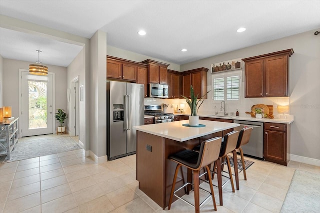 12327 Halfmoon Lake Ter, Bradenton, FL 34211 - kitchen with appliances with stainless steel finishes, a breakfast bar, a center island, decorative backsplash, and recessed lighting