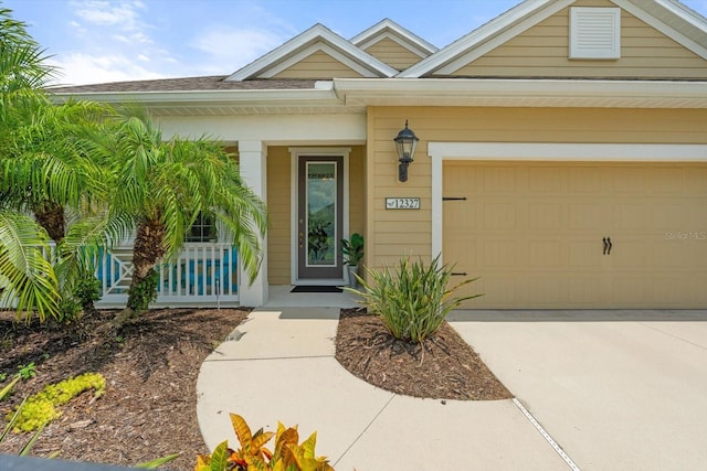 12327 Halfmoon Lake Ter, Bradenton, FL 34211 - view of exterior entry featuring concrete driveway, a garage, and covered porch
