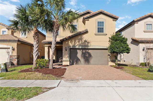 5545 Misty Oak Cir, Davenport, FL 33837 - mediterranean / spanish-style house with a tile roof, decorative driveway, a garage, and stucco siding
