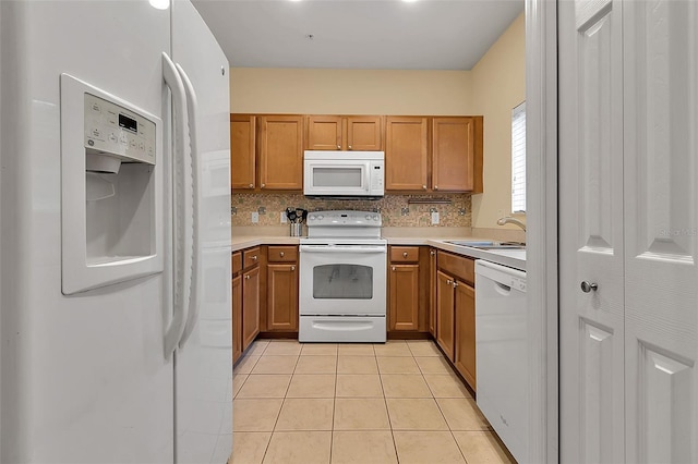 3707 45th Ter W Unit 104, Bradenton, FL 34210 - kitchen with white appliances, a sink, light tile patterned floors, brown cabinetry, and light countertops