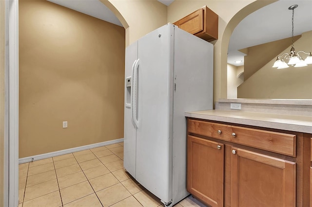 3707 45th Ter W Unit 104, Bradenton, FL 34210 - kitchen with white fridge with ice dispenser, arched walkways, light countertops, and brown cabinetry