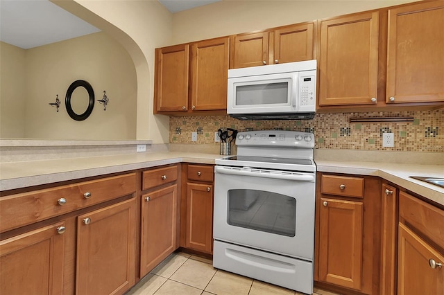 3707 45th Ter W Unit 104, Bradenton, FL 34210 - kitchen with white appliances, decorative backsplash, brown cabinets, and light countertops