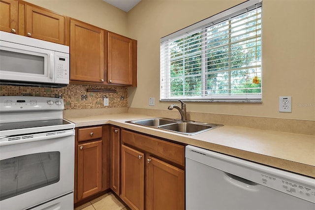 3707 45th Ter W Unit 104, Bradenton, FL 34210 - kitchen featuring white appliances, a sink, light countertops, brown cabinetry, and decorative backsplash