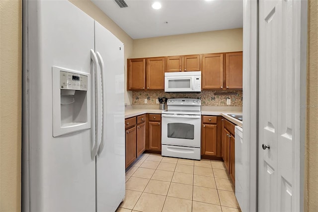 3707 45th Ter W Unit 104, Bradenton, FL 34210 - kitchen featuring white appliances, light tile patterned floors, brown cabinets, light countertops, and recessed lighting