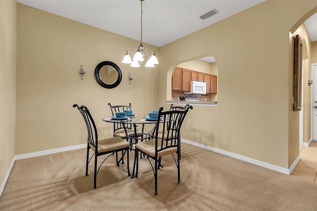 3707 45th Ter W Unit 104, Bradenton, FL 34210 - dining room with arched walkways, light carpet, a chandelier, and baseboards