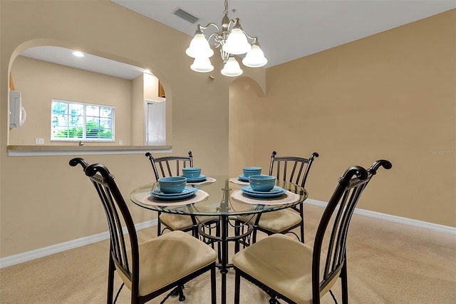 3707 45th Ter W Unit 104, Bradenton, FL 34210 - dining room featuring arched walkways, a chandelier, light colored carpet, and baseboards