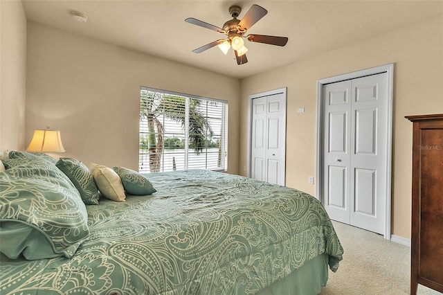 3707 45th Ter W Unit 104, Bradenton, FL 34210 - bedroom with light colored carpet, two closets, a ceiling fan, and baseboards