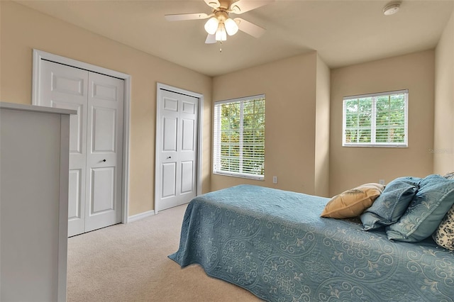 3707 45th Ter W Unit 104, Bradenton, FL 34210 - carpeted bedroom featuring multiple closets, multiple windows, baseboards, and a ceiling fan