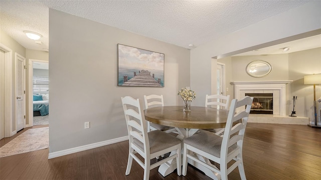4611 Spahn St, Sarasota, FL 34232 - dining space featuring a textured ceiling, wood finished floors, baseboards, and a tiled fireplace