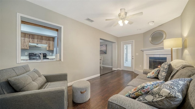4611 Spahn St, Sarasota, FL 34232 - living area with dark wood-style floors, ceiling fan, baseboards, and a fireplace