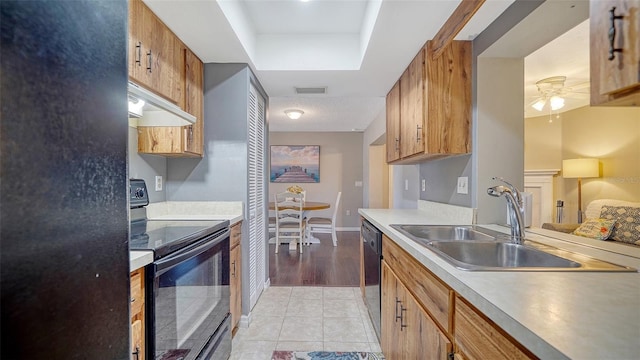 4611 Spahn St, Sarasota, FL 34232 - kitchen with black appliances, a sink, under cabinet range hood, light countertops, and brown cabinetry