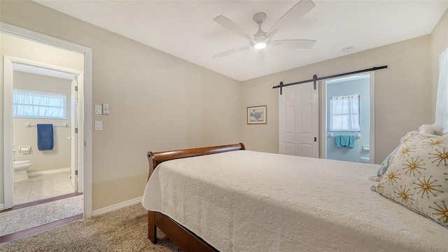 4611 Spahn St, Sarasota, FL 34232 - carpeted bedroom featuring a barn door, ceiling fan, ensuite bath, and baseboards